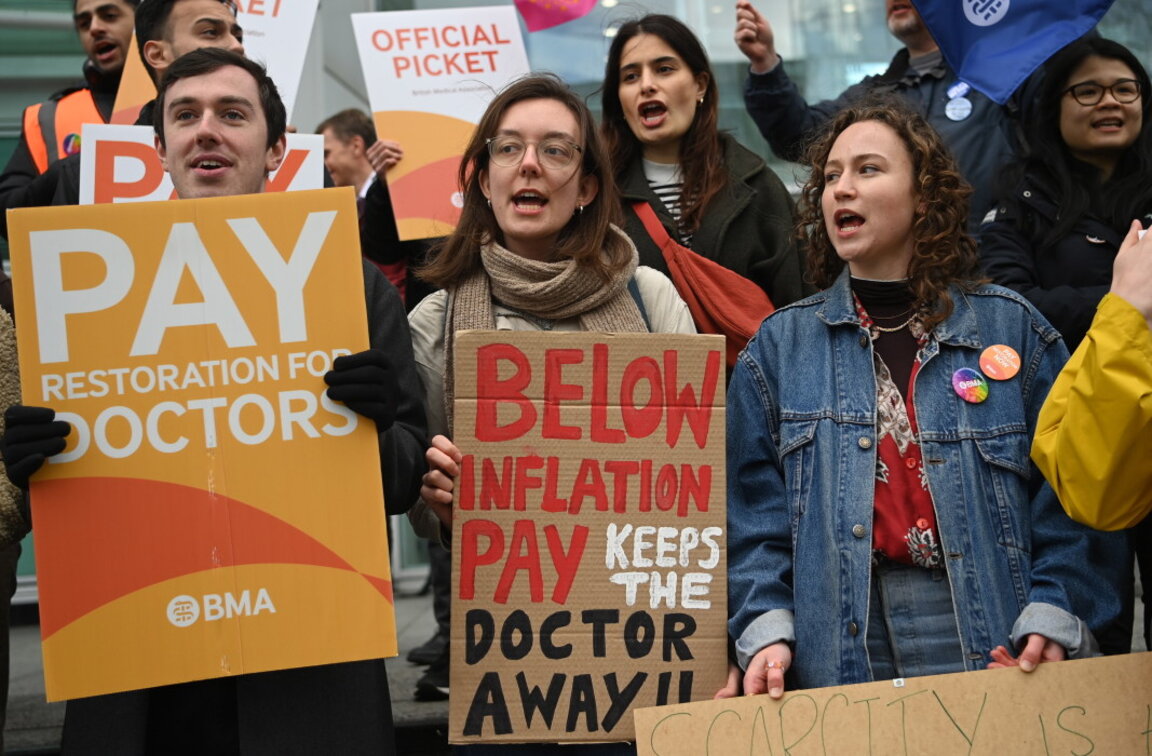 Младши лекари държат плакати, докато стачкуват пред болницата на Университетския колеж в Лондон, 11 април 2023 г.