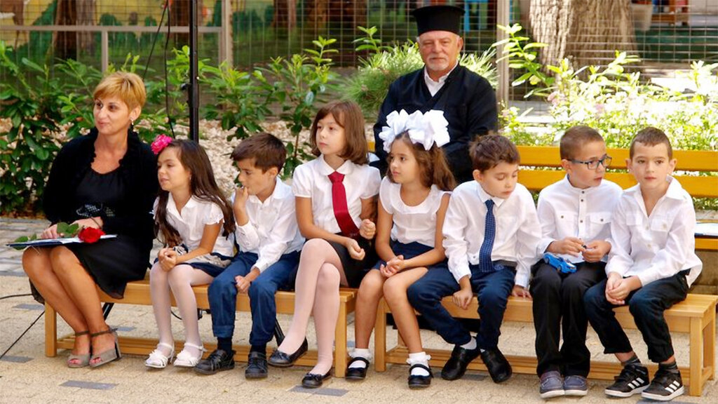 Father Tancho Yanchev with children from the Bulgarian school.