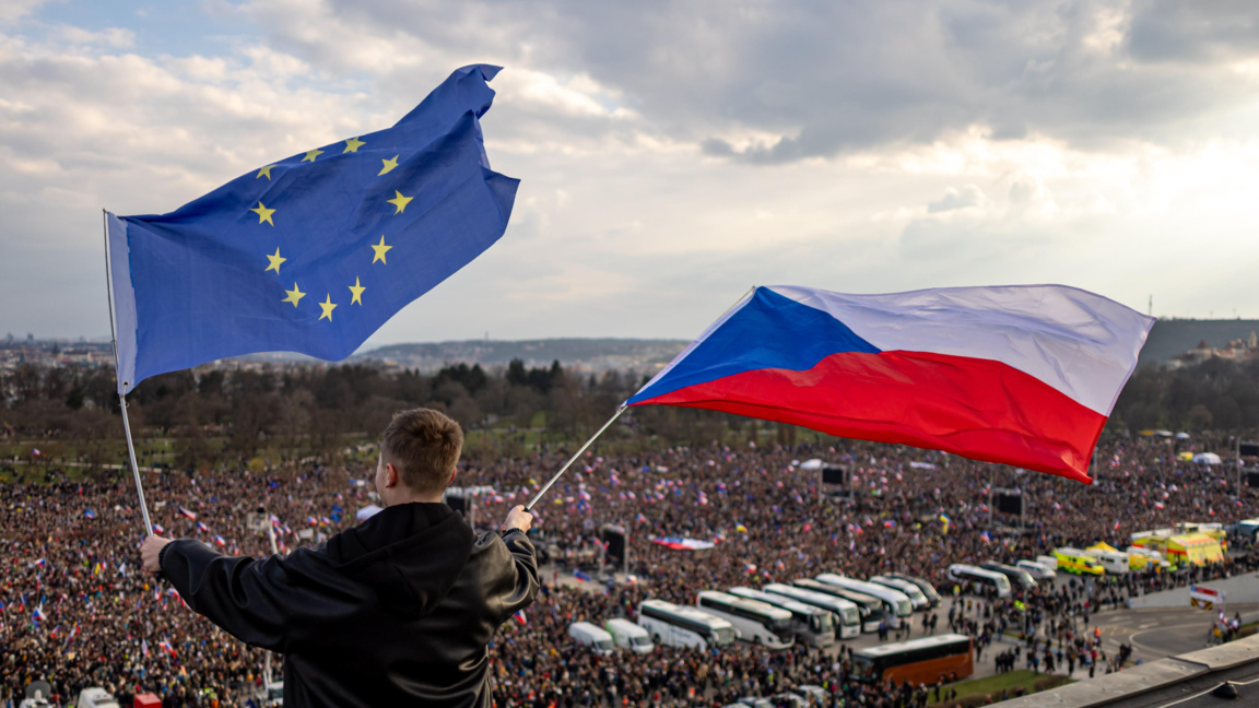 Протестиращ развява чешко и европейско знаме на антиправителствения протест в Прага, 21 март 2026 г.