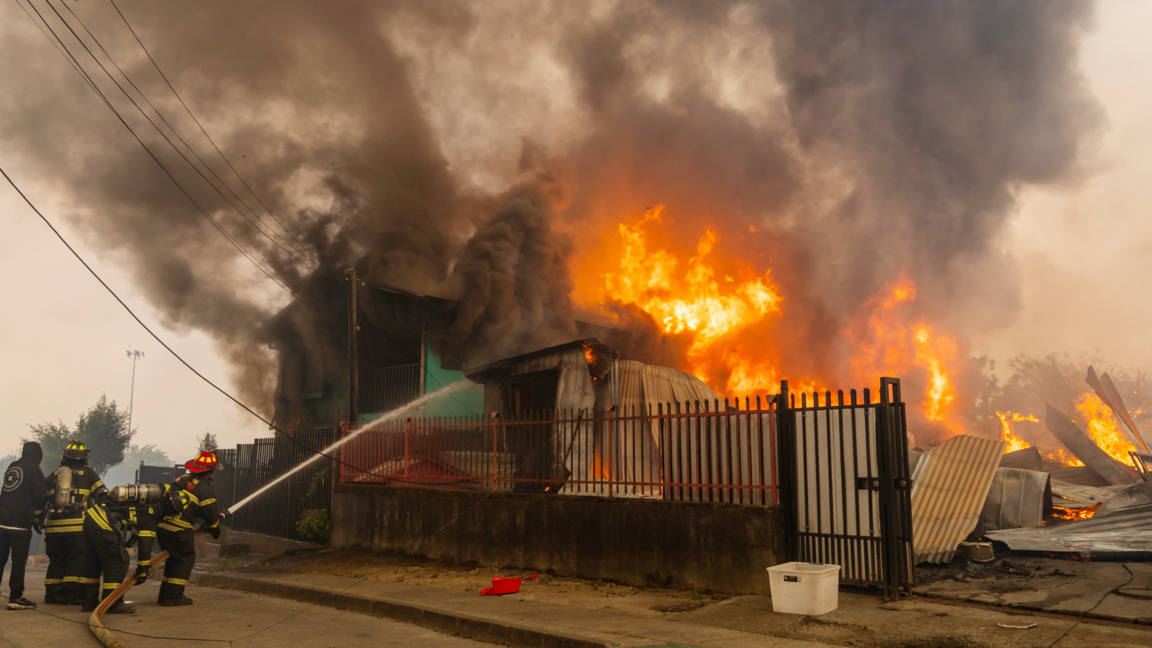 Пожарникари се борят с пожар, обхванал къща, в пристанищния град Лиркен, Чили, 18 януари 2026 г.