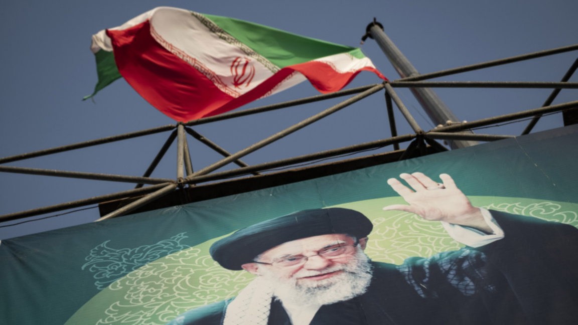Флагът на Иран се развява над лика на върховния лидер аятолах Али Хаменей в Техеран