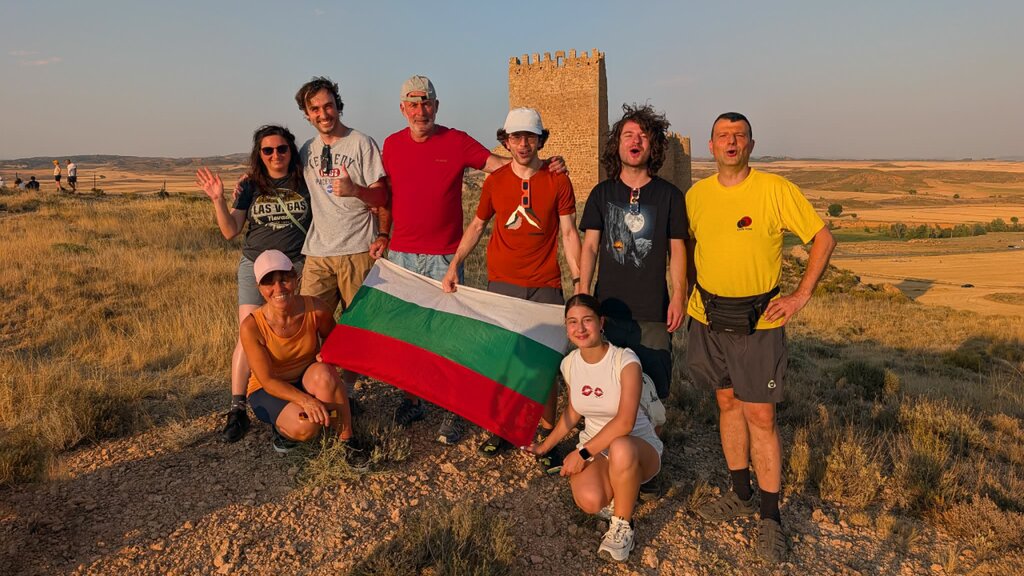 Los tres cazadores de eclipses con sus familias frente al castillo medieval, junto con sus familias