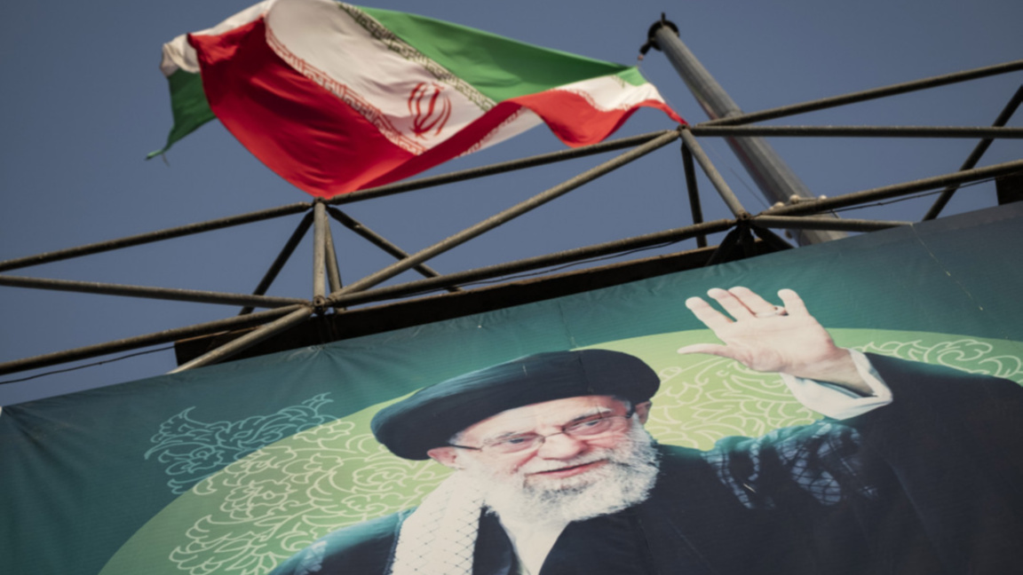 Флагът на Иран се развява над лика на върховния лидер аятолах Али Хаменей в Техеран.