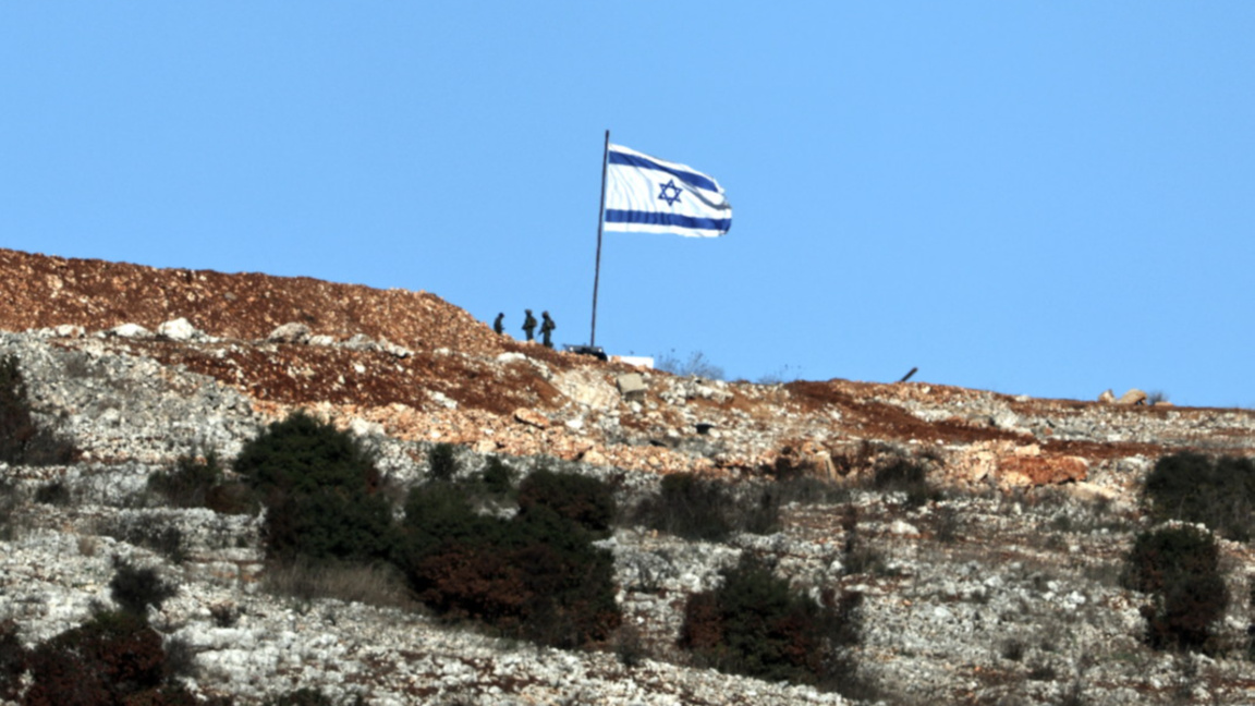 Израелски войници стоят до знаме от ливанската страна на границата, архив