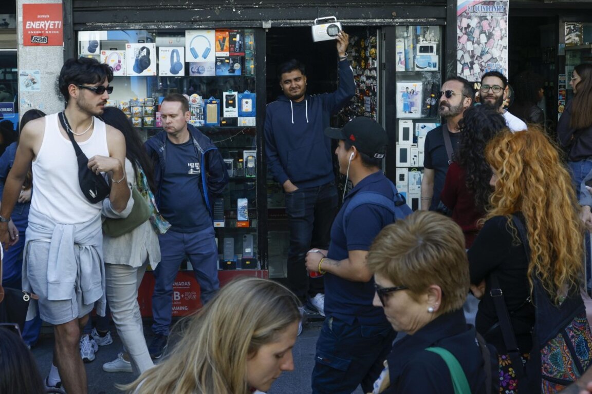 Хората слушат новини по радио с батерии, след като токът спря в Мадрид, Испания, 28 април 2025 г.