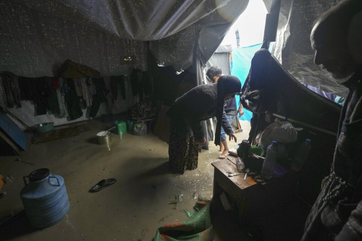 Четиридесет и девет годишната майка на осем деца Манал Лубад изгребва днес вода от наводнената си палатка в бежанския лагер в Дейр ал Балах, в централната част на Ивицата Газа.