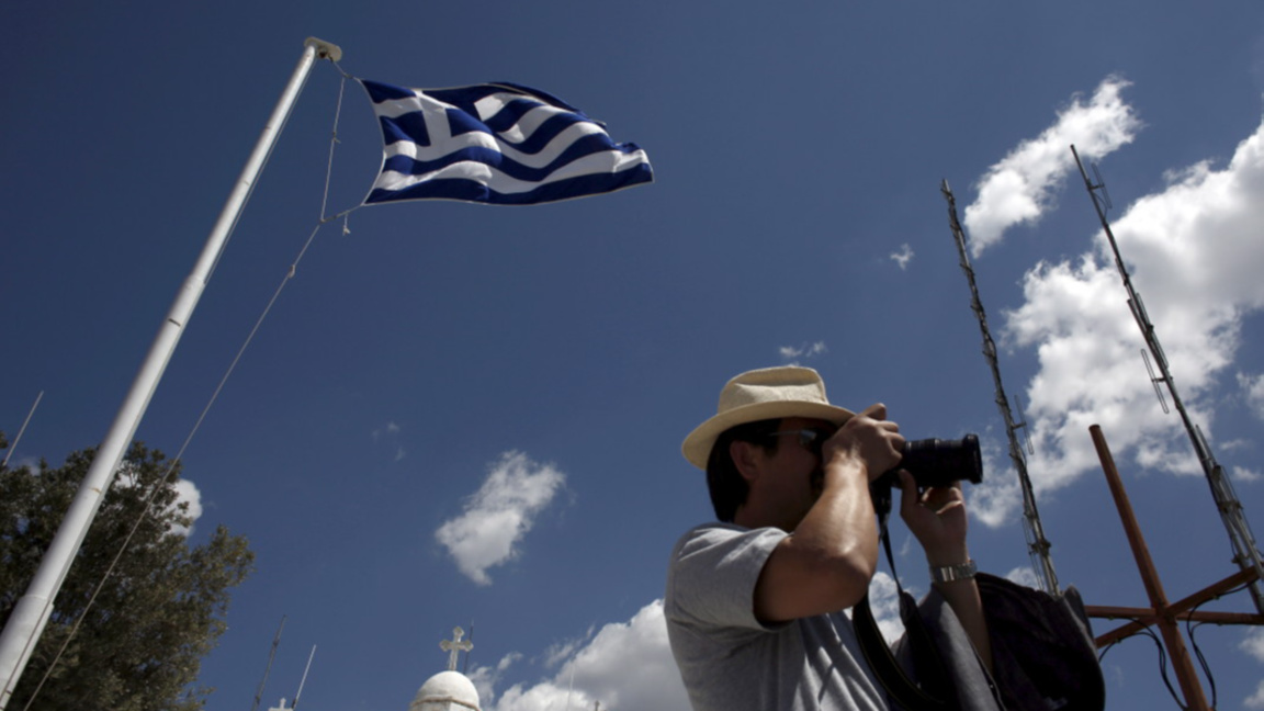 Турист прави снимка на фона на църквата "Свети Георги" в Атина.