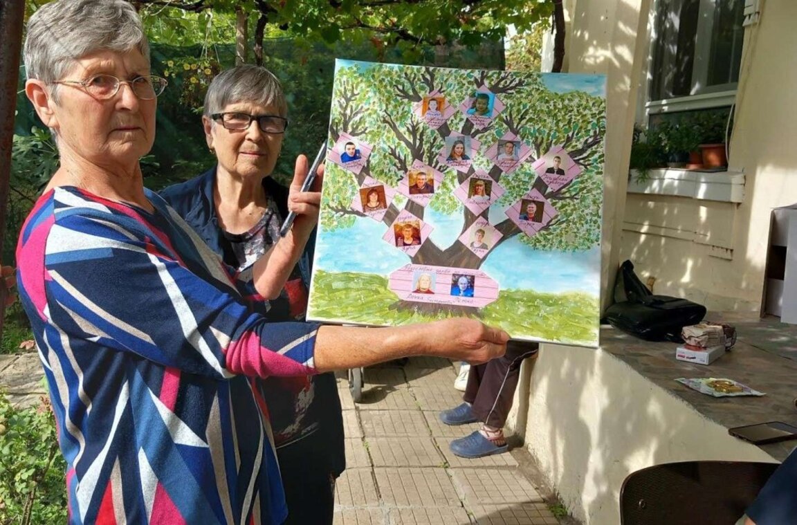 Снимката е архив на Община Стара Загора.  
Дъщерите на 101-годишния 
дядо Петко Колев от с. Михайлово позират с родословно дърво на своите предци и наследници.