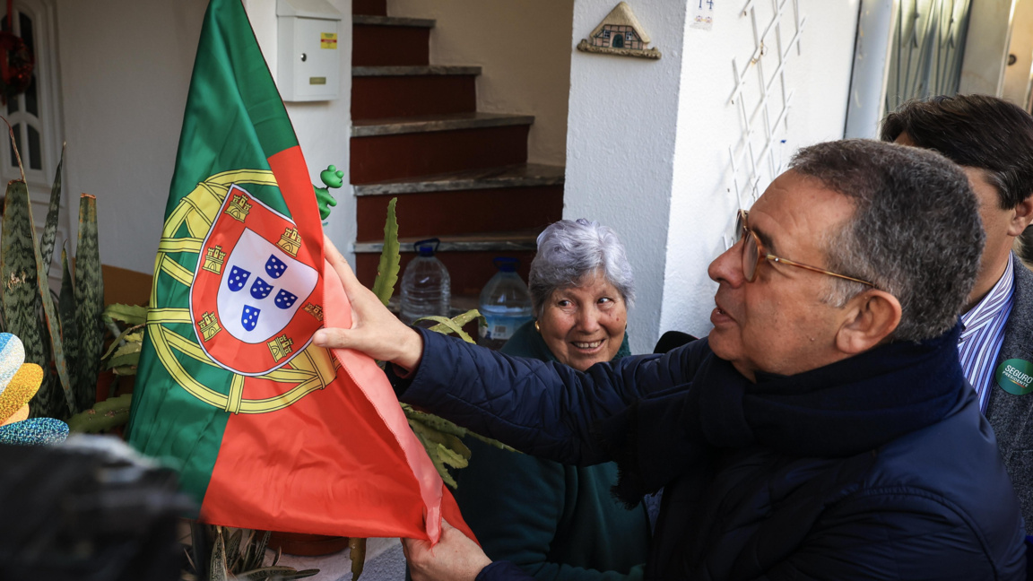 Кандидатът за президент Антонио Жозе Сегуро държи португалското знаме по време на предизборно събитие