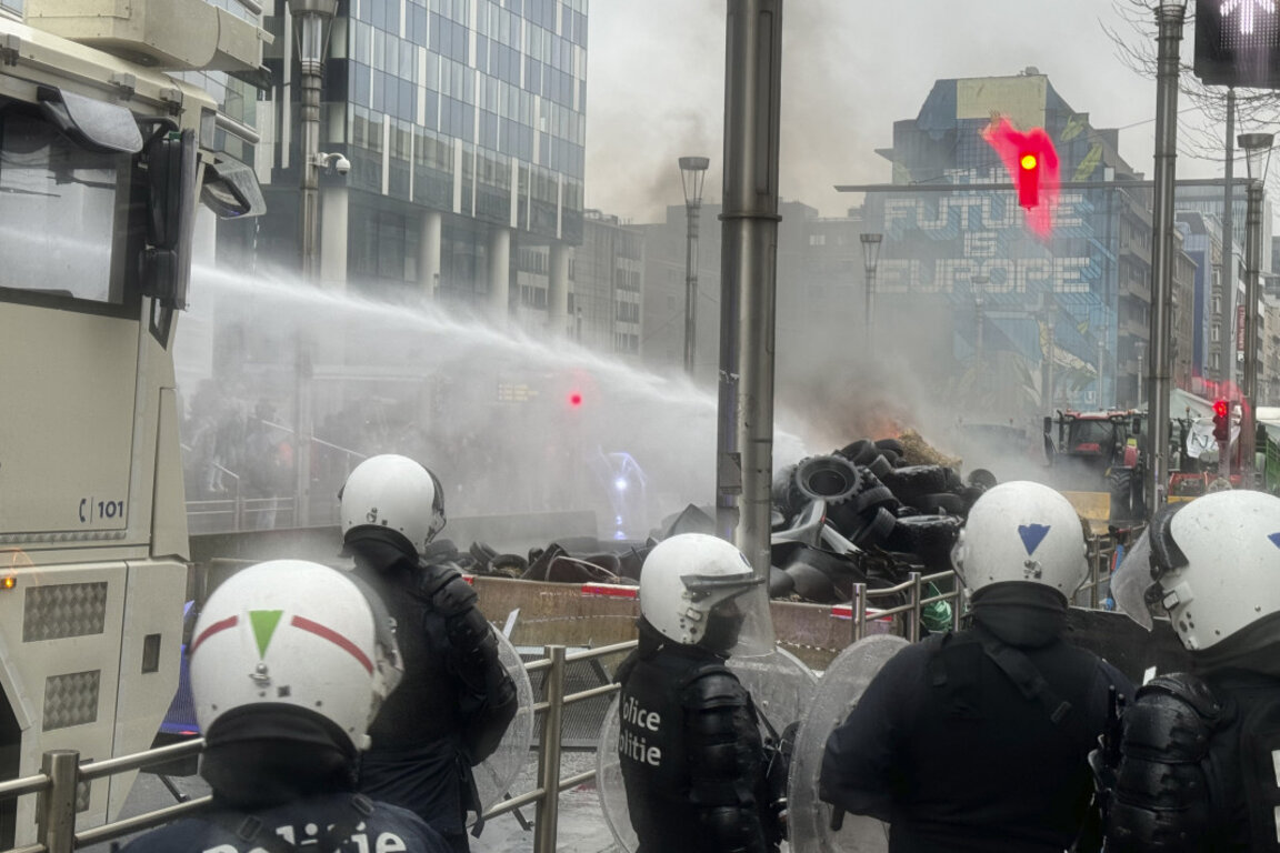 Полицията реагира с водни струи на запалени гуми от протестиращите фермери в Брюксел, 26 февруари 2024 г.