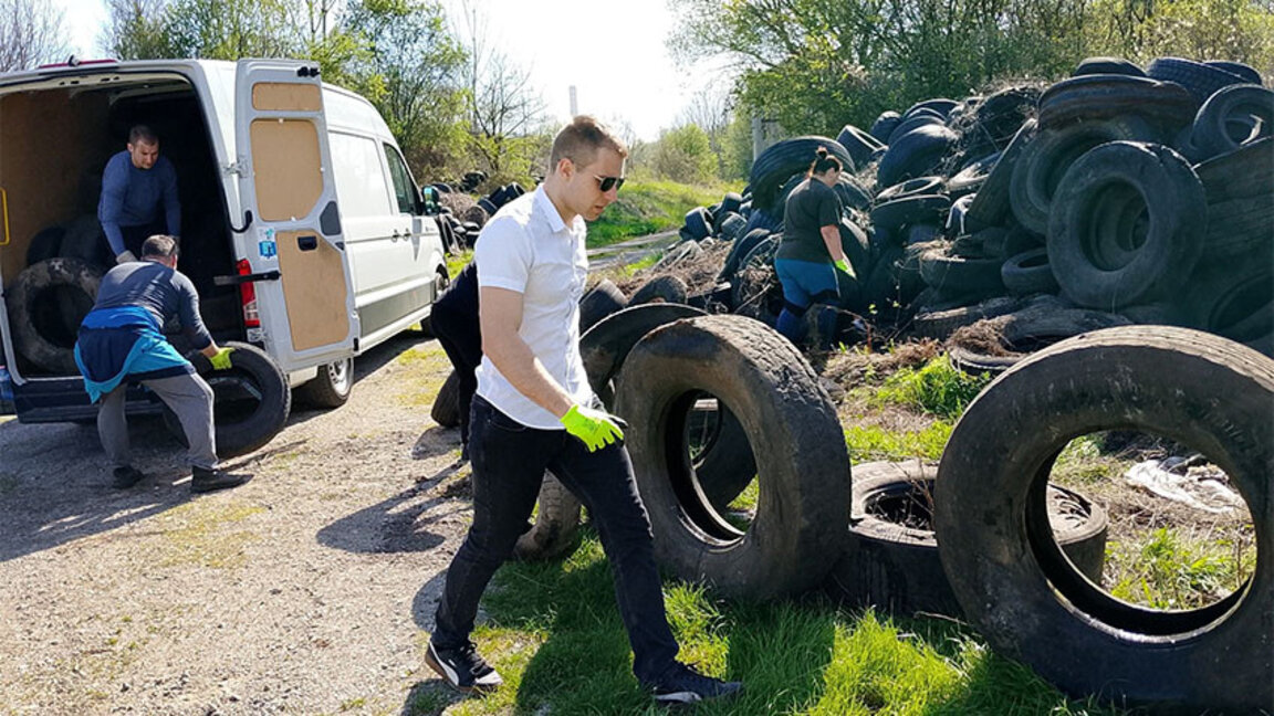 Сговорни доброволци махат планина от автомобилни гуми
