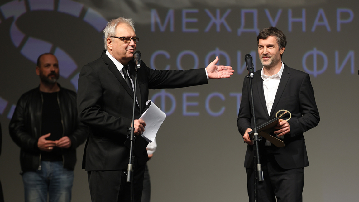 Fondatorul și directorul de lungă durată al Festivalului Internațional de Film „Sofia Film Fest”, Stefan Kitanov – Kita (în stânga), îi înmânează premiul regizorului filmului „Dirijorul”, Ondřej Provazník.