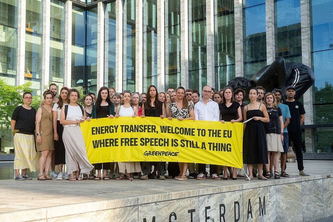 Активисти на "Грийнпийс" разпънаха банер пред съда в Амстердам с надпис: "Енерджи трансфър", добре дошли в ЕС, където свободата на словото все още означава нещо".