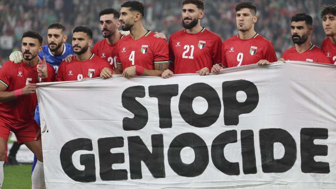 Играчите на палестинския национален отбор по футбол държат транспарант с надпис "Спрете геноцида" преди приятелския мач в Билбао