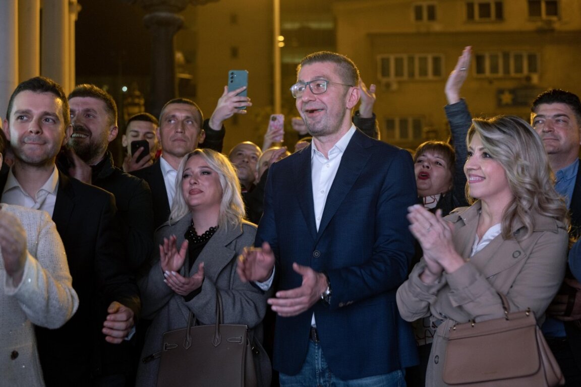 Премиерът и лидер на ВМРО-ДПМНЕ Християн Мицкоски, съпругата му Роза (вдясно) и привърженици приветстват новините за изборната победа.