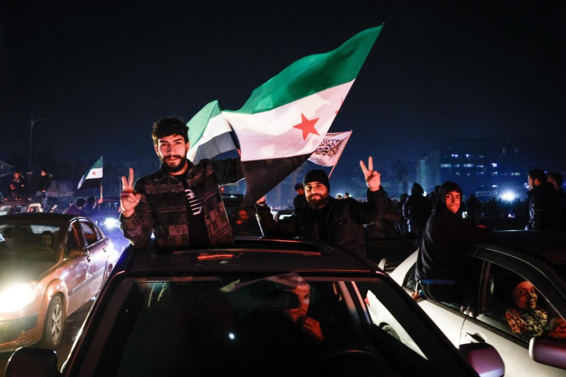 Сирийци развяват знамена на опозицията с три звезди, докато празнуват падането на Асад в Дамаск, Сирия, 11 декември 2024 г.