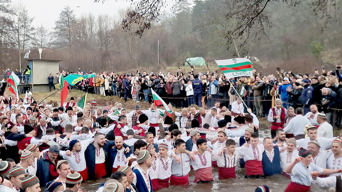 Epiphany ritual: men in folk costumes dance in Bulgaria’s Tundzha River