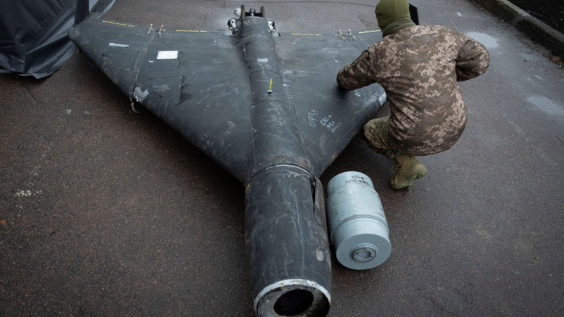Украински военнослужещ оглежда свален руски дрон "Шахед"