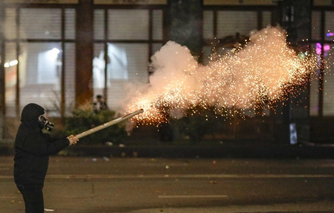 Привърженик на грузинската опозиция изстрелва фойерверки към полицията по време на протест пред парламента в Тбилиси, Грузия, 2 декември 2024 г.