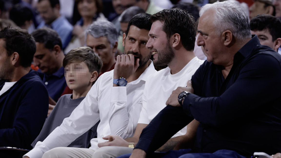 Новак Джокович (с бялата риза) си говори с баскетболната звезда Лука Дончич на мач в Мадрид.