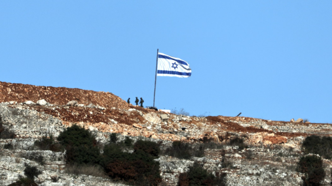 Израелски войници стоят до израелско знаме от ливанската страна на границата, близо до южното ливанско село Марун ал-Рас, 26 ноември 2024 г., на фона на трансгранични военни действия между "Хизбула" и Израел.