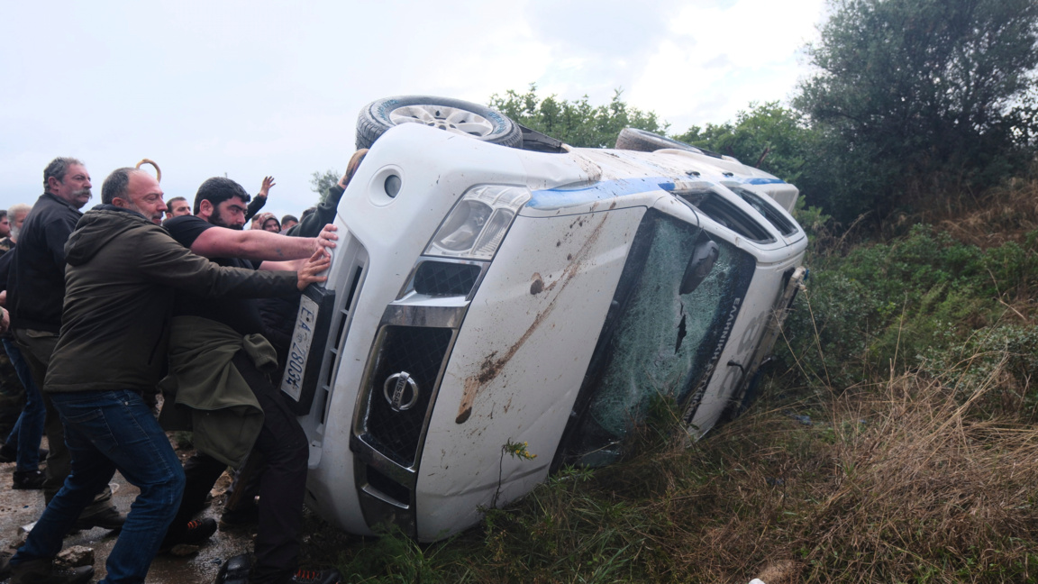 Фермери преобръщат полицейска кола при сблъсъци с полицаи, блокиращи похода им към летището в Ханя на остров Крит, Гърция, 8 декември 2025 г..