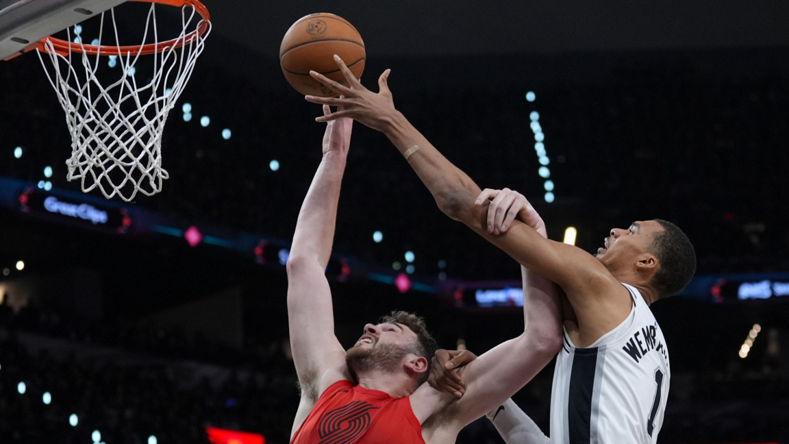 Уенбаняма от Сан Антонио (вдясно) се опитва да блокира стрелбата на Клингън от Портланд.