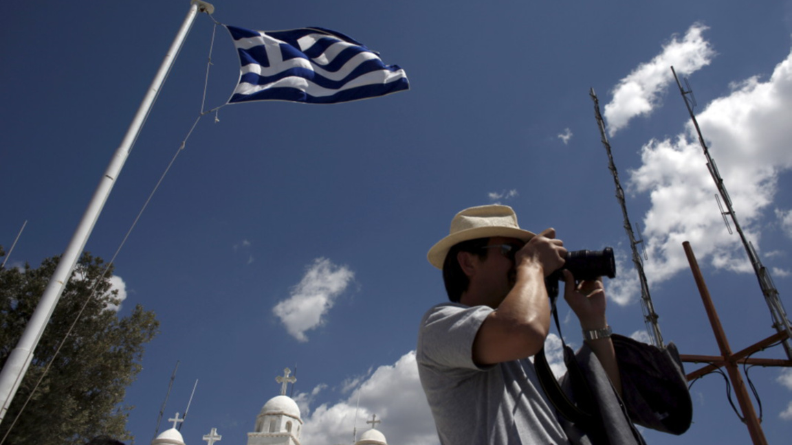 Турист прави снимка на фона на църквата "Свети Георги" в Атина.