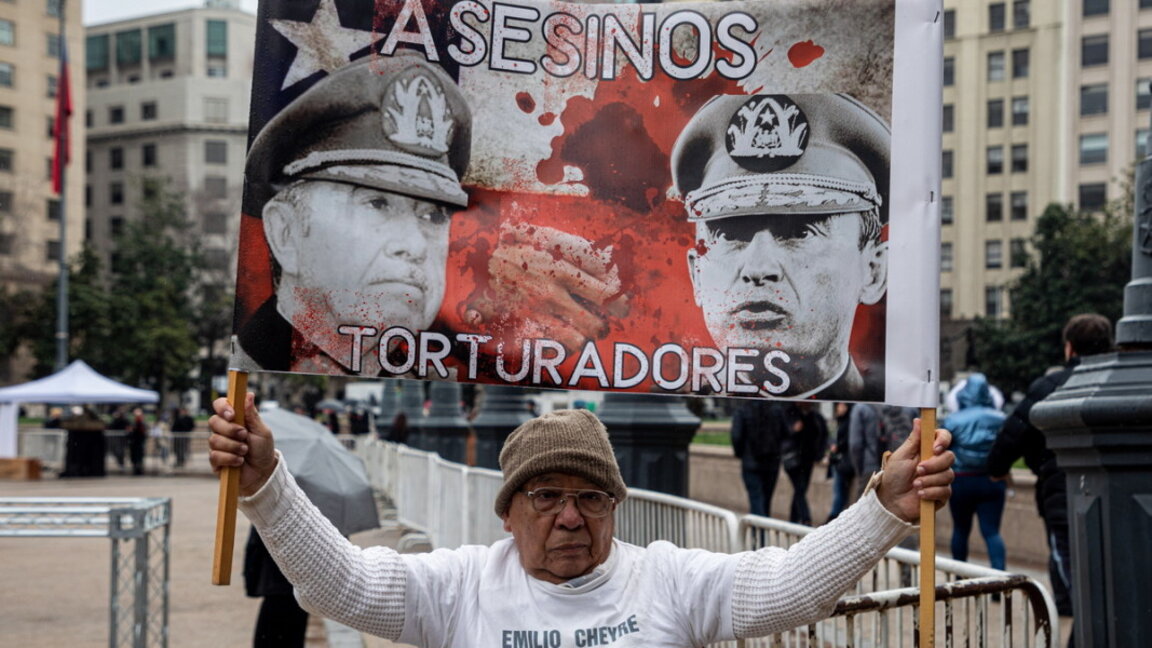 Демонстрант с плакат с надпис "Атентатори – жертви", недалеч от двореца "Монеда", напомня за събитията от 1970 г., когато Салвадор Алиенде побеждава на изборите. Хиляди демонстранти си припомниха за избирането на Алиенде, за да отбележат 50-годишнината от преврата през 1973 г., който слага началото на диктатурата на Аугусто Пиночет.