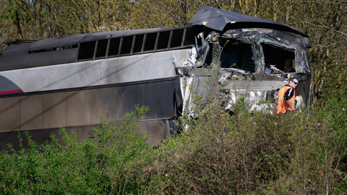 Железопътен работник стои близо до високоскоростния влак (TGV), който се сблъска с камион, превозващ военно оборудване в Северна Франция, 7 април 2026 г.