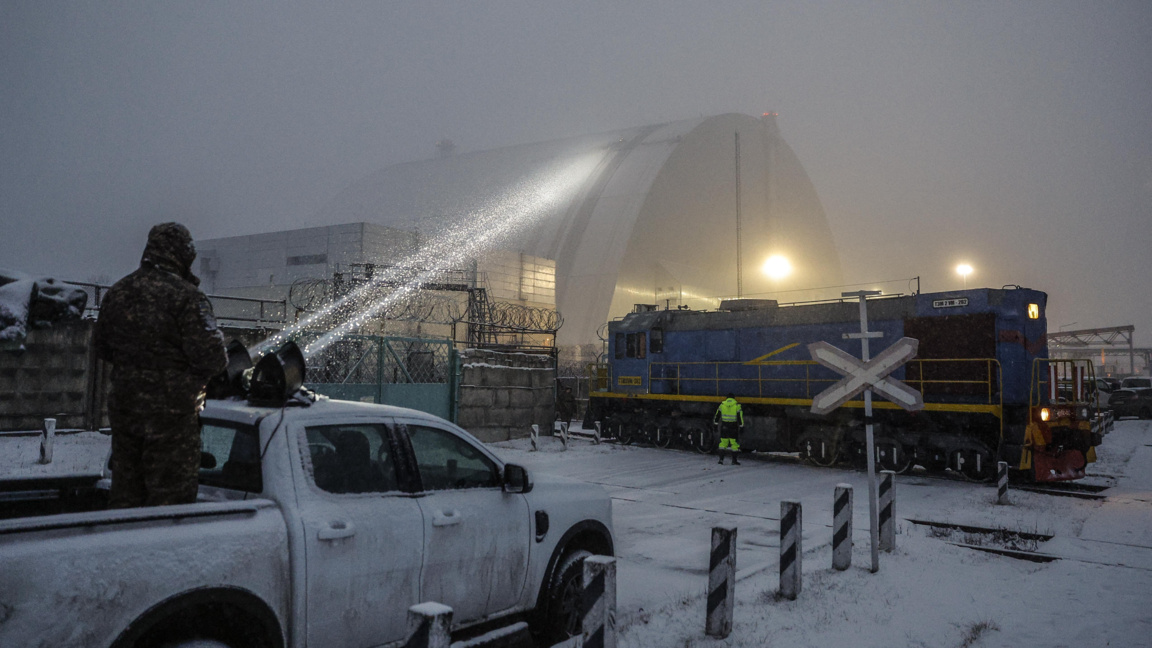 Украински военен насочва прожектор към повредения вероятно при руска атака защитен купол на бившия четвърти реактор на Чернобилската АЕЦ, 14 февруари 2025 г.