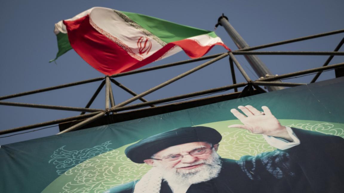 Флагът на Иран се развява над лика на върховния лидер аятолах Али Хаменей в Техеран.