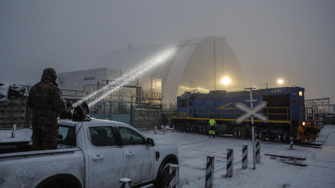 Украински военен насочва прожектор към повредения вероятно при руска атака защитен купол на бившия четвърти реактор на Чернобилската АЕЦ, 14 февруари 2025 г.