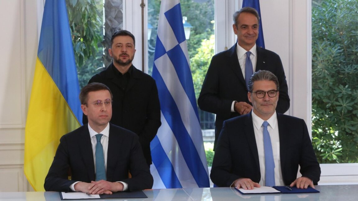 Изпълнителният директор на DEPA, Константинос Ксифарас (вдясно), и изпълнителният директор на Naftogaz Group, Сергей Корецки (вляво), подписват енергийно споразумение в присъствието на Мицотакис и Зеленски.